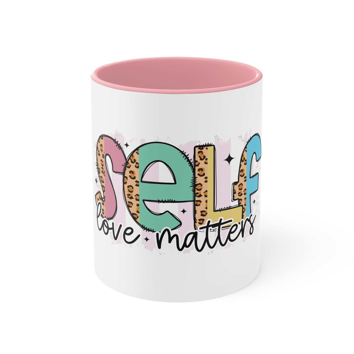 White ceramic self-love accent mug with pink interior and handle, featuring colorful "Self love matters" text design.
