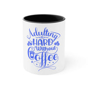 White ceramic Adulting Accent Mug with black interior and blue "Adulting is hard without coffee" text design
